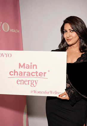 Woman holding a Movyo sign that reads Main character energy